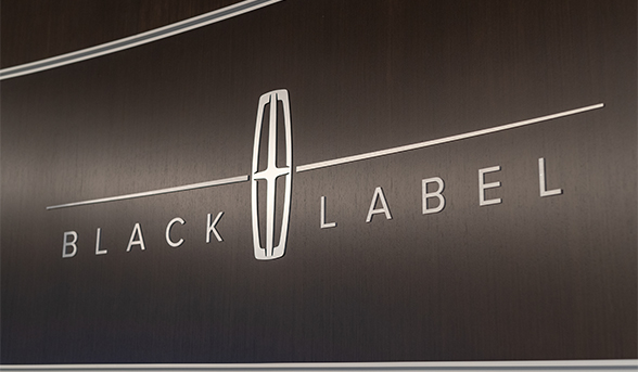 Silver Lincoln Black Label logo over a walnut wood panel.
