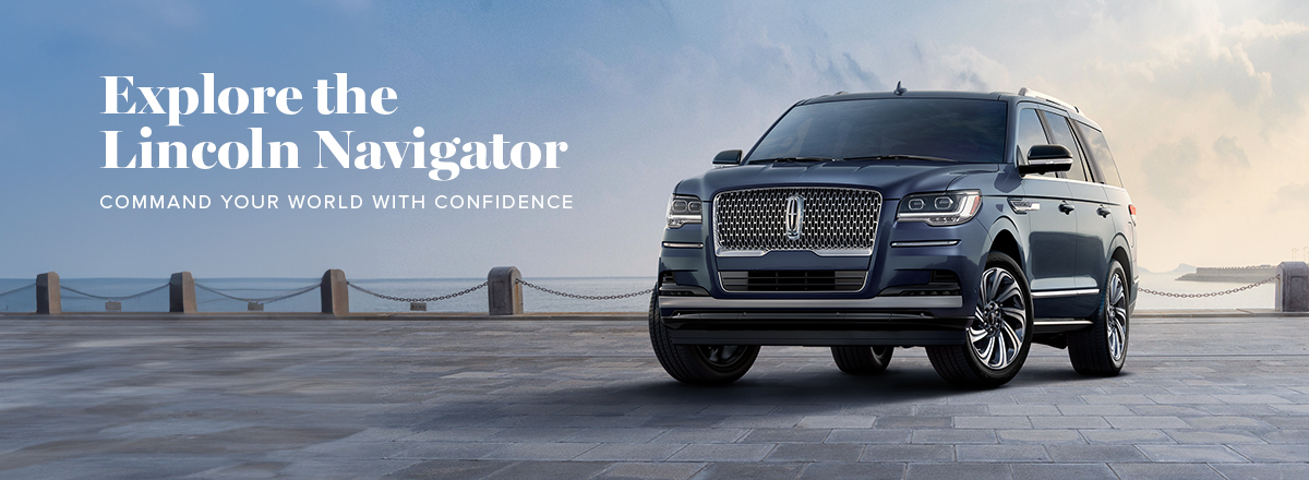 A Lincoln Navigator is parked in front of a mid-century modern home on a sunny day