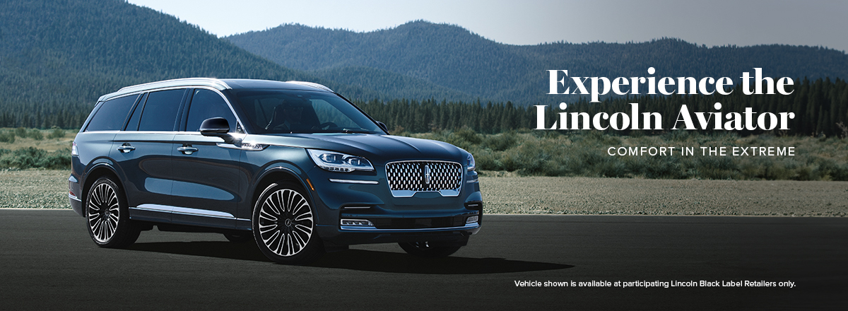 A Lincoln Aviator Black Label in Flight Blue is parked by a mountain road.