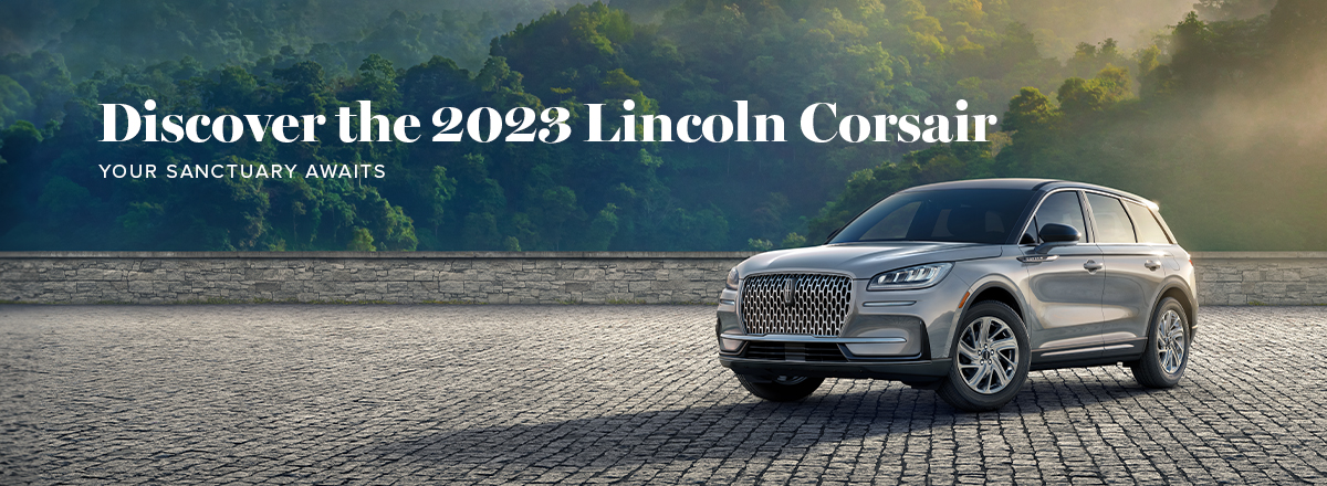 A 2023 Lincoln Corsair in Silver Radiance is parked by a forest overlook.
