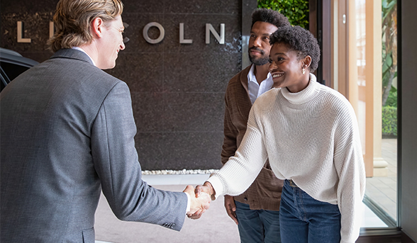 A couple enter the Lincoln Experience Center and are warmly welcomed by a host.